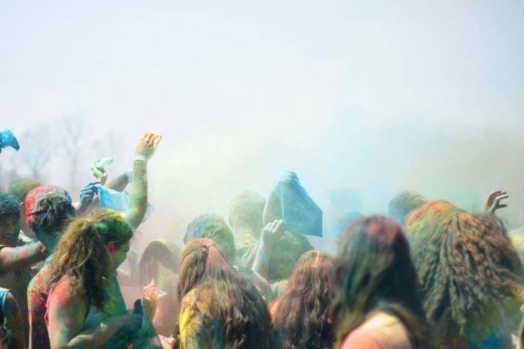 Holi participants throw powder in the air and dance during the celebration. Holi is an Hindu spring celebration that is also called the festival of colors.