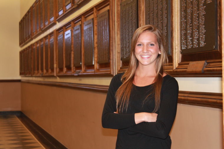 Ashley Robin, Bronze Tablet recipient and senior in Business, stands in front of the names of former Bronze Tablet scholars in the Main Library. The Bronze Tablet award recipients for the class of 2014 will be hung on the Main Librarys wall in November 2014.