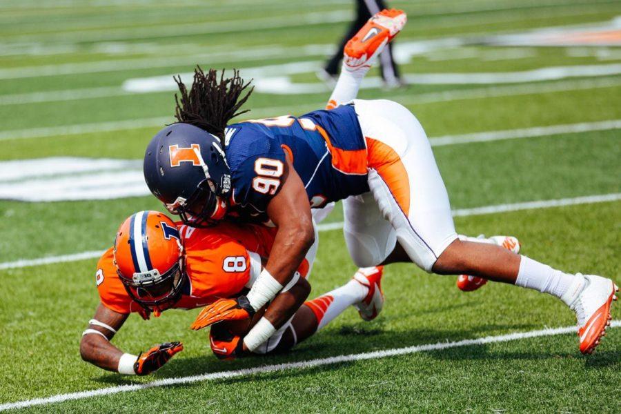 Illinois DeJazz Woods (90) tackles down Geronimo Allison (8) during the annual Orange and Blue Spring Game at Memorial Stadium, on Saturday, April 12, 2014. The Blue team won 38-7.