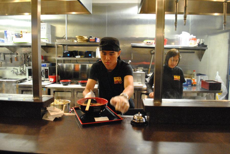 Koto Ramen employee, Calvin Law, serves a fresh bowl of ramen beside manager, Amy Chook.