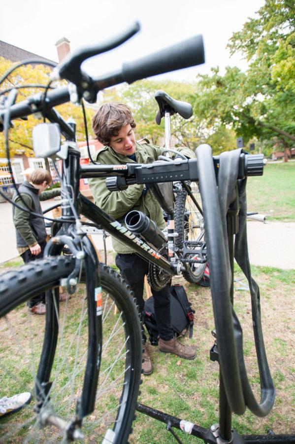 Thane Fowler, Sophomore in General Studies, president of BikeFace fixes bicycles on the main quad to raise fund for making human power nut grinder on Oct. 23, 2013