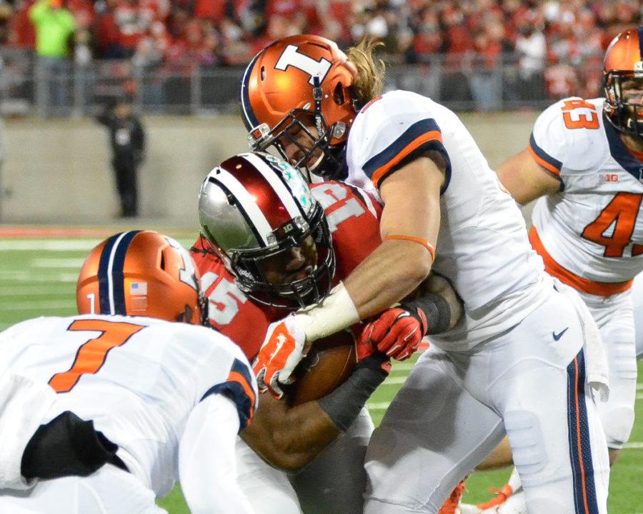 Illinois’ Taylor Barton (3) tackles Ohio State’s Ezekiel Elliott (15) during the game at Ohio Stadium in Columbus, Ohio, on Saturday. The Illini lost 55-14, which was the team’s fourth road-game loss.