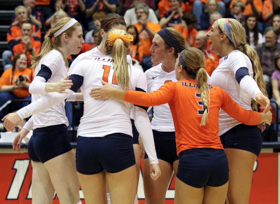 Illinois' Liz McMahon (14) &amp; Anna Dorn (5) set up a block against a hit from Michigan's Adeja Lambert (11) during the game against the University of Michigan at Huff Hall on Saturday.