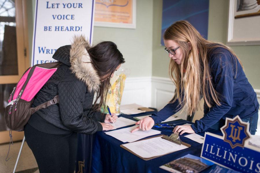 Rebecca Wilson (right), junior in LAS, shows Jakia Hussian, freshman in LAS, a list of potential topics to write to the Illinois State Legislature during the Student Alumni Ambassadorss letter writing campaign at the Illini Union on Wednesday.
