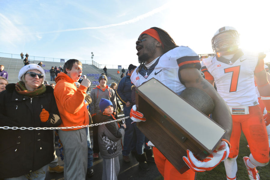 Illinois' Earnest Thomas III carries the Land of Lincoln trophy after the game against Northwestern at Ryan Field in Evanston, Ill. on Saturday. The Illini won 47-33.