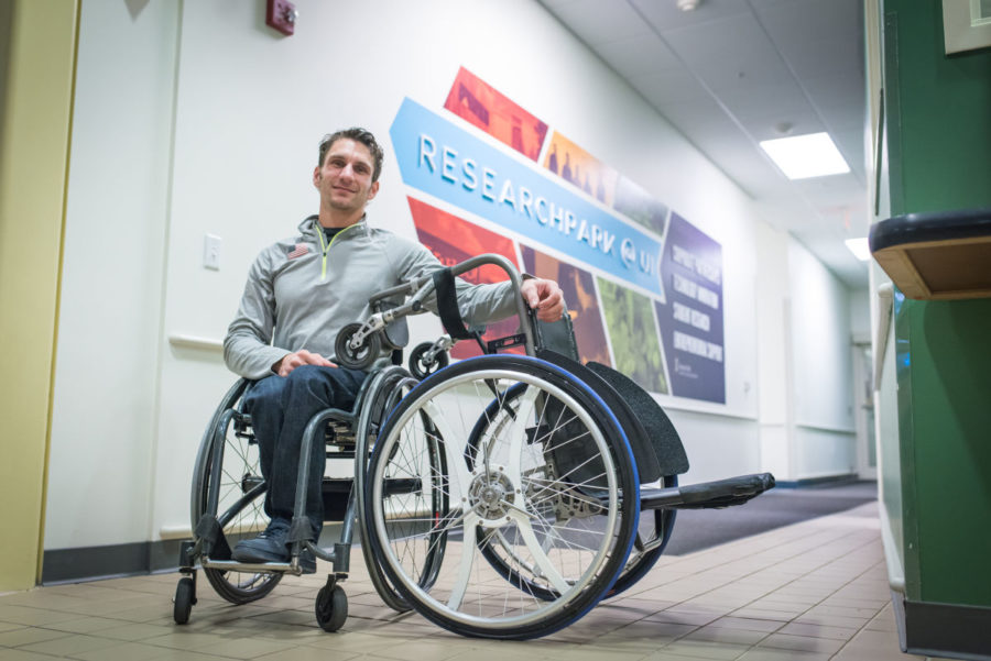 Josh George, graduate of the College of Media and founding partner of Intelliwheels, poses beside an early prototype he constructed.