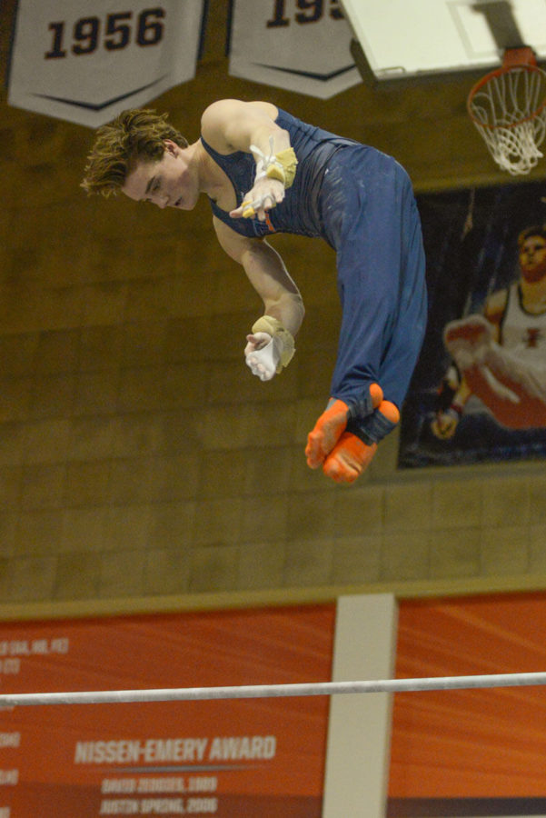 Illinois Tyson Bull performs a high bar routine at the Orange and Blue Exhibition at Huff Hall on Sunday.