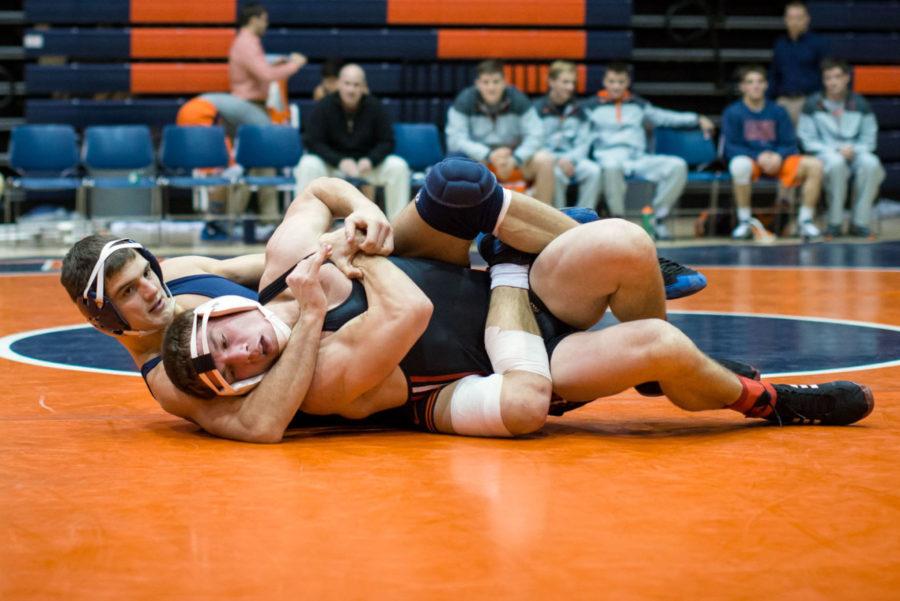 Illinois Jackson Morse maintains control of his opponent on the mat during the opening match of the season against ISUE at Huff Hall on November 9. The Illini won 44-0.