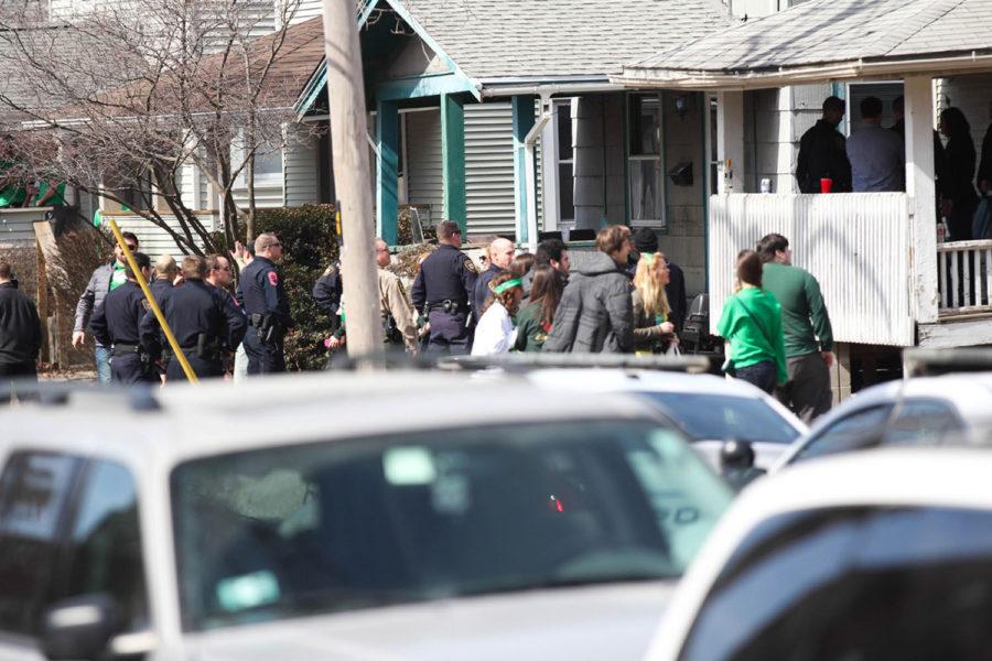 Police officers gather around a house on E. Daniel, on Unofficial St. Patricks Day, Friday, Mar. 7, 2014.