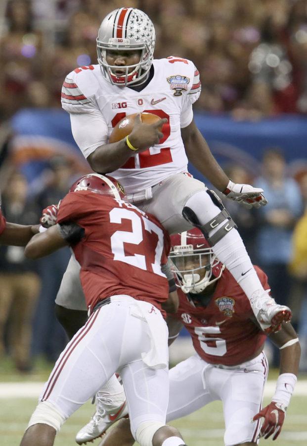 Ohio State quarterback Cardale Jones leaps over Alabamas Nick Perry and Ronnie Clark during a first quarter run of the Allstate Sugar Bowl and College Football Playoff Semifinal on Thursday, Jan. 1, 2015 at Mercedes-Benz Superdome in New Orleans. (Phil Masturzo/Akron Beacon Journal/TNS)