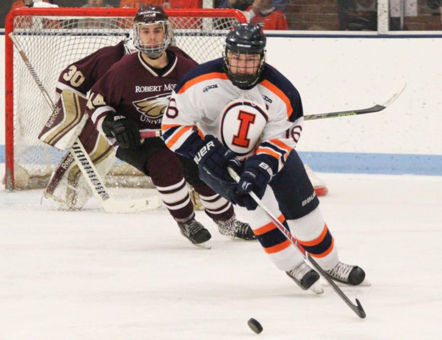 Illinois John Olen (16) maintains control of the puck as Robert Morris Jake Floro (44) comes up from behind during the hockey game vs. Robert Morris at the Ice Arena on Saturday, Jan. 24, 2015. The Illini lost 4-3.