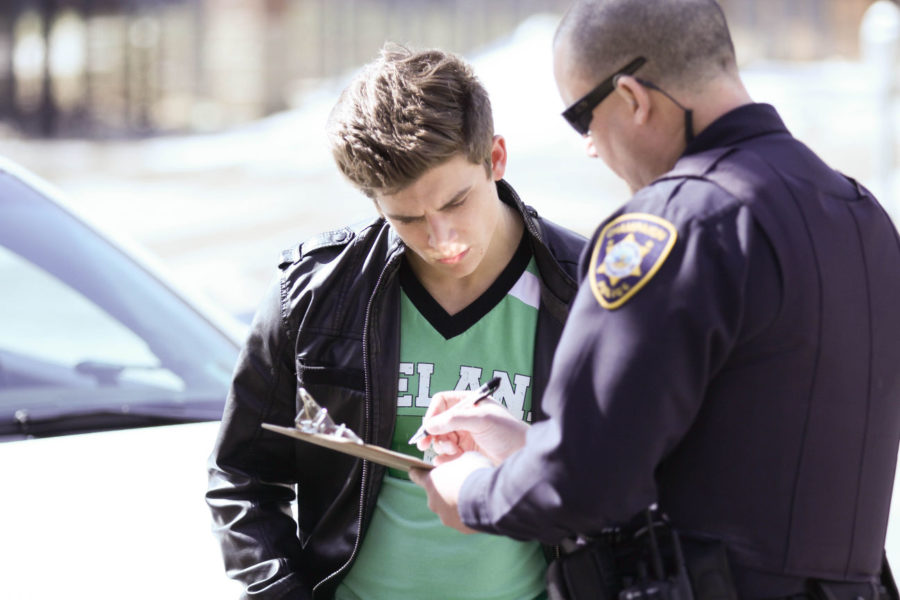 A police officer talks to an individual on Fourth and Daniel, on Unofficial St. Patricks Day, Friday, Mar. 7, 2014.
