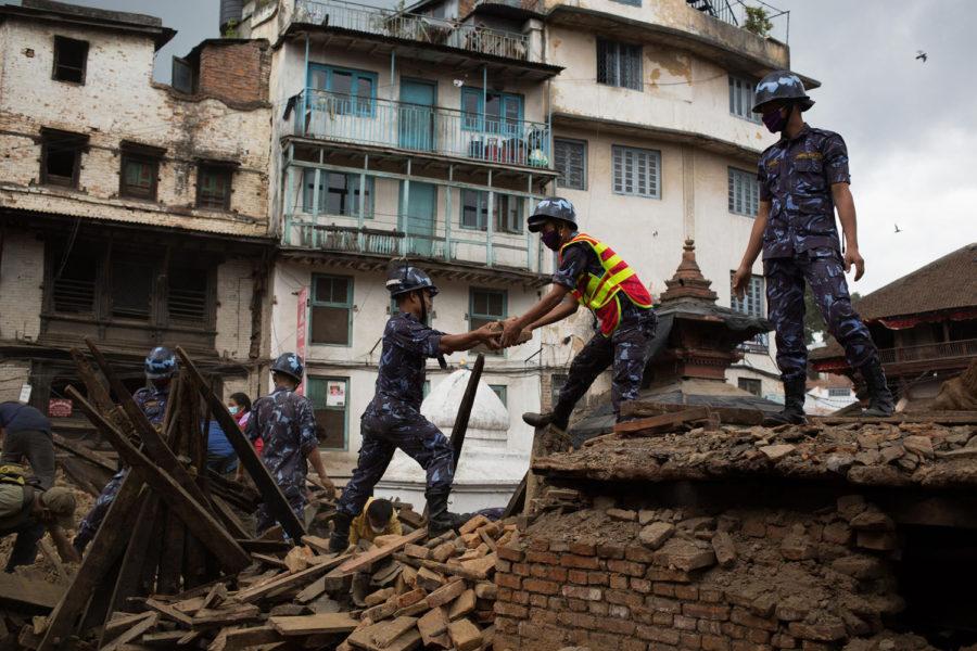 Workers dig through the debris of fallen buildings on Tuesday in Kathmandu, Nepal. The death toll from a powerful earthquake in Nepal climbed to 4,555 and a total of 8,299 others were injured, Nepal Police said in a statement Tuesday.