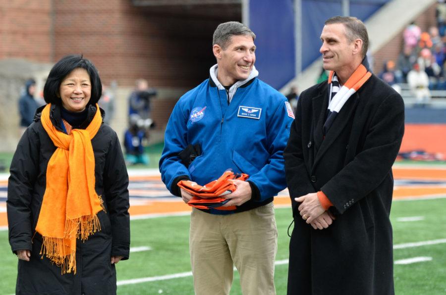 NASA astronaut and former Illini Mike Hopkins presents a jersey and flag to Chancellor Phyllis Wise and Athletic Director Mike Thomas during the game against Iowa at Memorial Stadium on Saturday, Nov. 15, 2014. Thomas responded Monday to Simon Cvijanovics Twitter accusations of Tim Beckman.