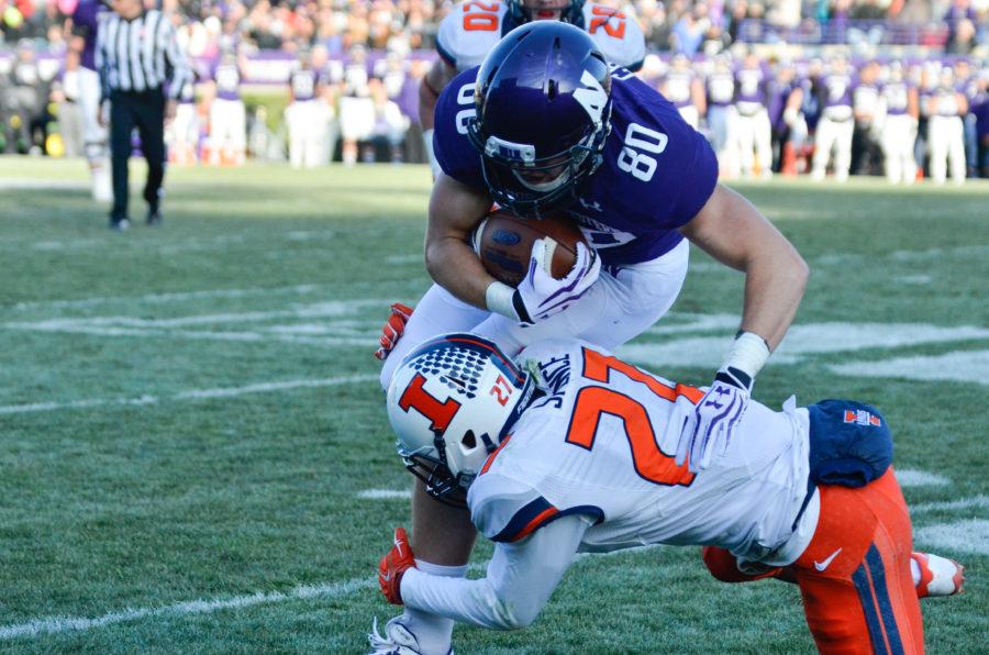 Illinois Eaton Spence (27) tackles Northwesterns Austin Carr (80) during the game at Ryan Field in Evanston, Ill. on Saturday, Nov. 29, 2014. The Illini won 47-33.