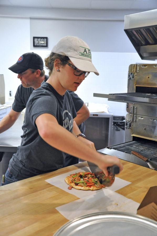 Helen Edna, sophomore in Business, cuts a freshly made pizza at Azzip Pizza on September 29, 2015.