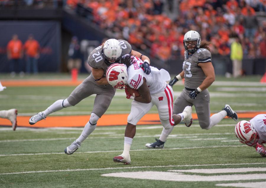 Defensive back Clayton Fedejelem takes down Wisconsin running back Dare Ogunbowale during Saturdays Homecoming game at Memorial Stadium. Illinois lost 13-24.