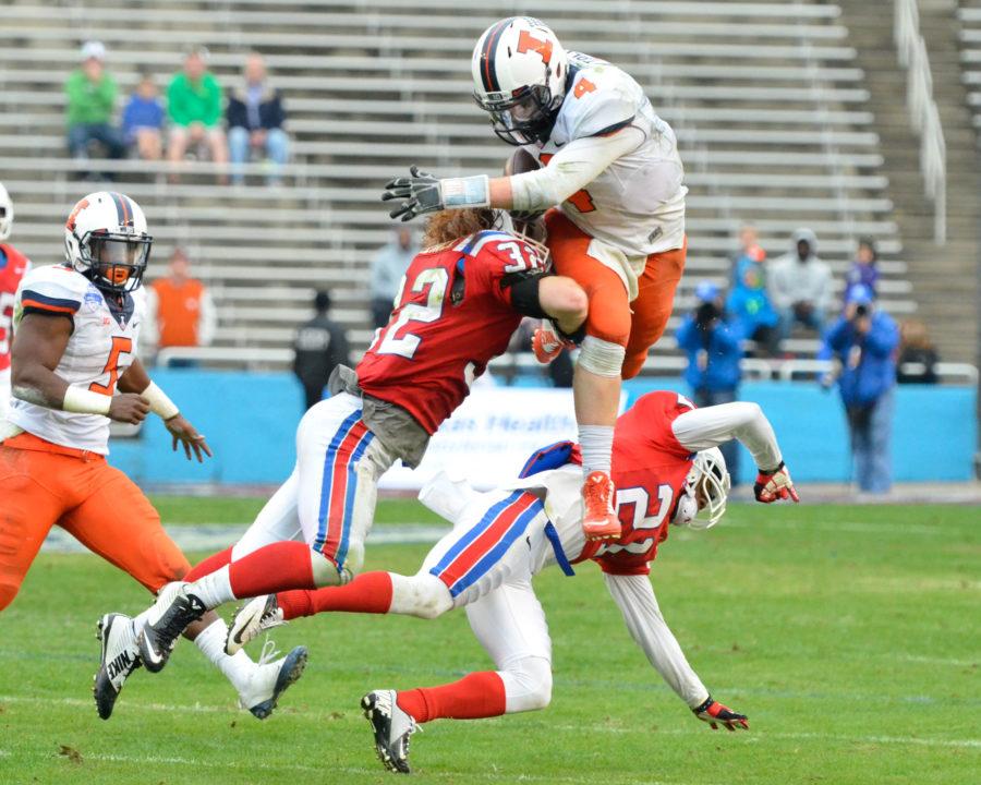 Illinois Reilly OToole (4) jumps to avoid a tackle during the Zaxbys Heart of Dallas Bowl against Louisiana Tech at Cotton Bowl Stadium in Dallas, Texas on Friday, Dec. 26, 2014. The Illini lost 35-18.