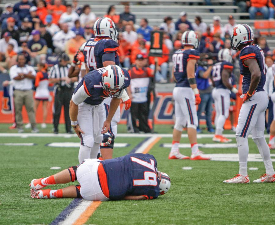 Back up quarterback Chayce Crouch leans down to check on injured lineman Zach Heath during the game against Western Illinois at Memorial Stadium on Saturday, Sept. 12.