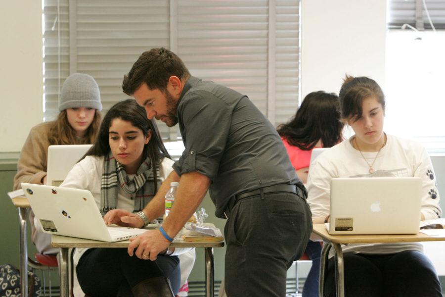 Isabelle Martini, a junior, gets help on her assignment from her English teacher Ed Sandt, center, during class, November 19, 2012, in Montvale, New Jersey. Pascack Hills High School has been issuing students laptop computers in their classrooms for the past nine years. (Tariq Zehawi/The Record/MCT)