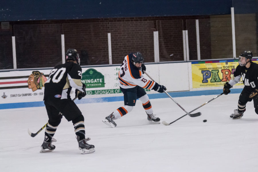 Illinois James Mcging (13) fights for puck during the game against Western Michigan University at the Ice Arena on Saturday, Dec. 12, 2015. Illinois won 4-3.