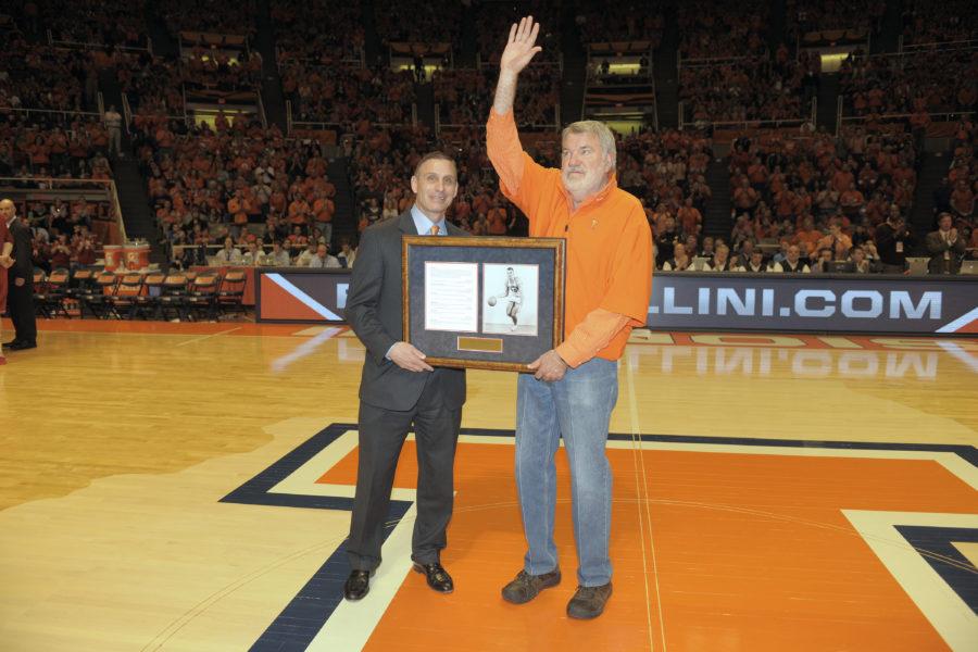 Former Athletic Director Mike Thomas hands Illini basketball legend Dave Downey a plaque commemorating Downeys all-time scoring record of 53 points. Downey has continued to play an integral part in Illinois athletics, donating $2 million for the creation of courtside Club 53 at the renovated State Farm Center