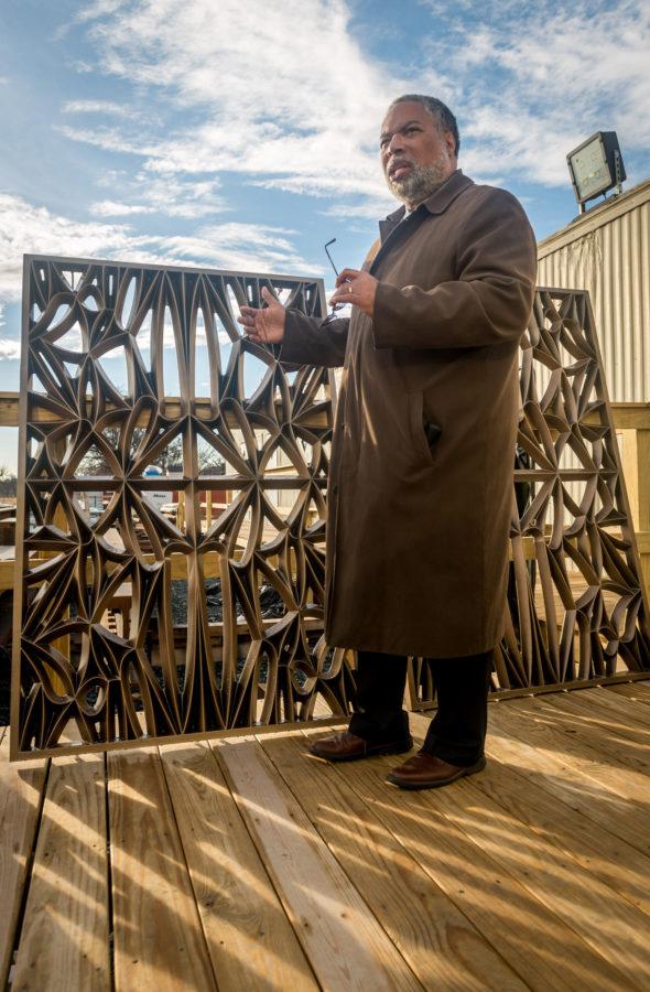Director of the Smithsonian Institute National Museum of African American History and Culture Lonnie Bunch III talks about the design of the bronze plated aluminum panels which will comprise the bronze and glass-panel façade, known as the Corona, during a tour of the museum construction site at 14th St. NW and Constitution Avenue in Washington, D.C. on Feb. 21, 2014. The Corona is a representation of traditional African architecture using modern materials and will visually define the museum. The Corona will hang from the top of the museum with no intermediate support on the side of building.