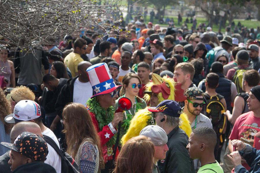 A man in a chicken suit walks around the crowd with his friend dressed as a pro-marijuana Uncle Sam. (Matt Sisneros/CU Independent)