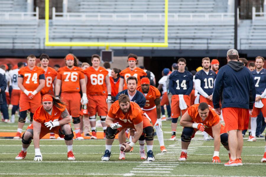 Joe Spencer (middle) snaps the ball to Wes Lunt during Illinois football's first spring practice Friday. Spencer is flanked by Gabe Megginson (left) and Nick Allegretti, who are likely new starters on Illinois' offensive line.