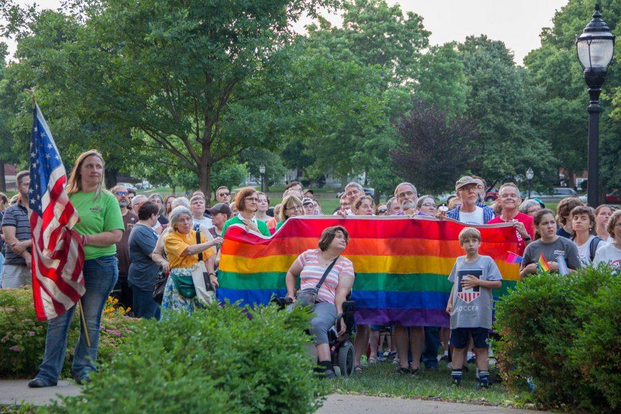 Community members listen speakers at the Vigil for Orlando at the West Side Park in Champaign on Tuesday, June 14, 2016.