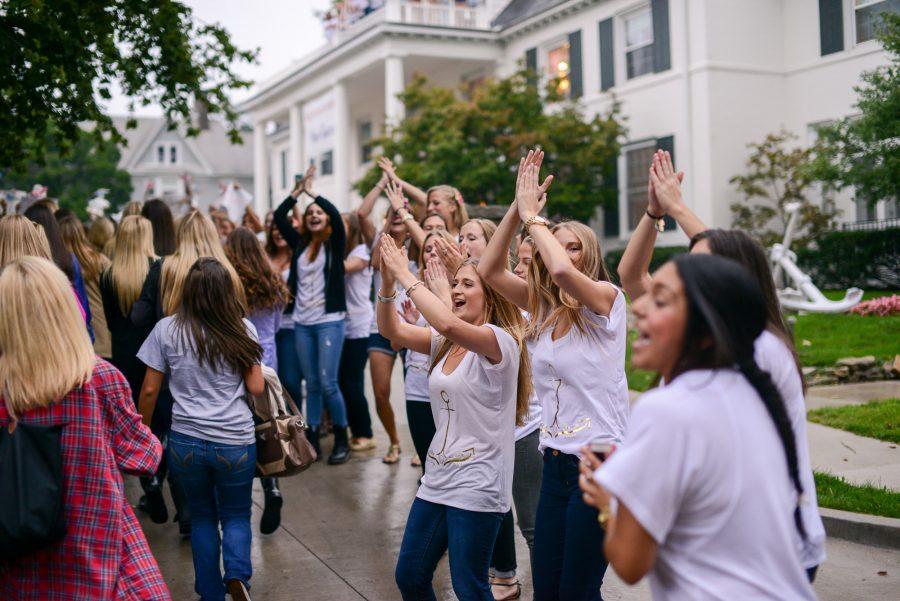 These sisters form a triangle with their arms and hands, showing sorority pride during Bid Day on Monday, Sept. 15, 2014.