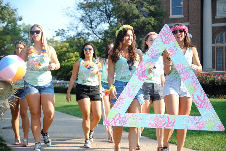 Alpha Gamma Delta sorority members arrive on the Quad to welcome their new pledge class.