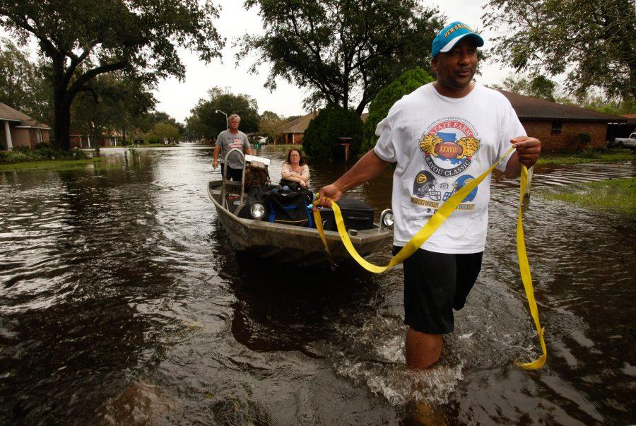 Leroy Smith, right, helps evacuate Michele Bowers with Hank Schlindwein, back, in La Place, Louisiana, on Thursday, August 30, 2012, amid flooding from Tropical Storm Isaac. (Carolyn Cole/Los Angeles Times/MCT)