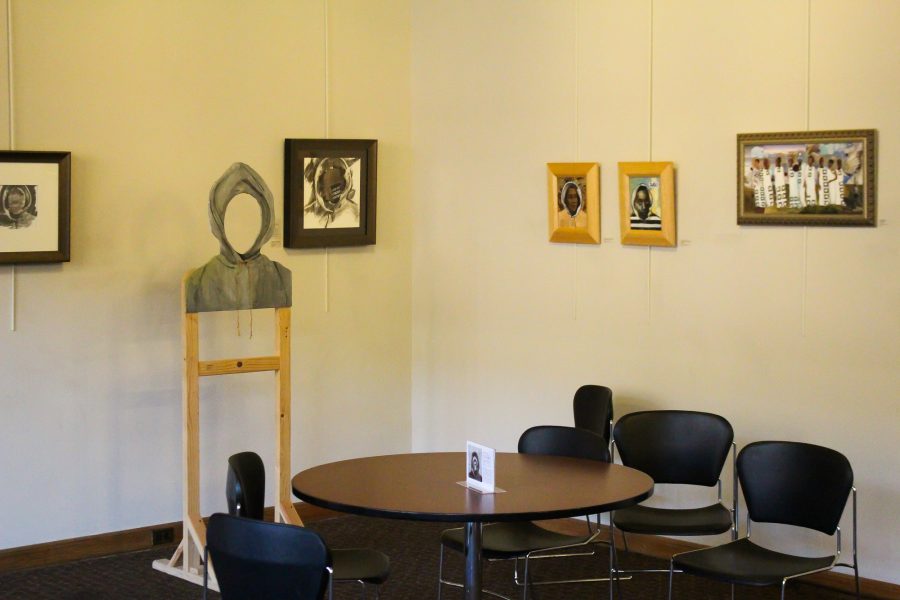 Artwork by Candace Hunter for her exhibit Hooded Truths sits on display at the University YMCA on Wright and Chalmers.