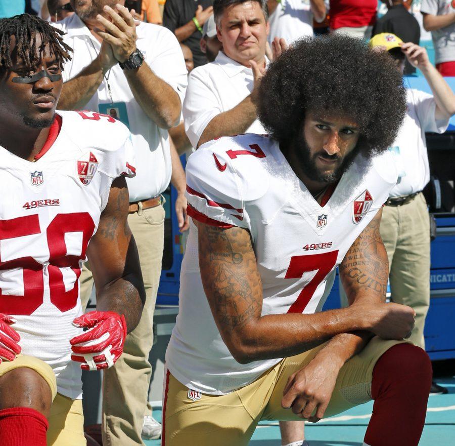 San Francisco 49ers outside linebacker Eli Harold (58) and quarterback Colin Kaepernick (7) take a knee during the national anthem before a game against the Miami Dolphins on Sunday, Nov. 27, 2016 at Hard Rock Stadium in Miami Gardens, Fla. (Al Diaz/Miami Herald/TNS)