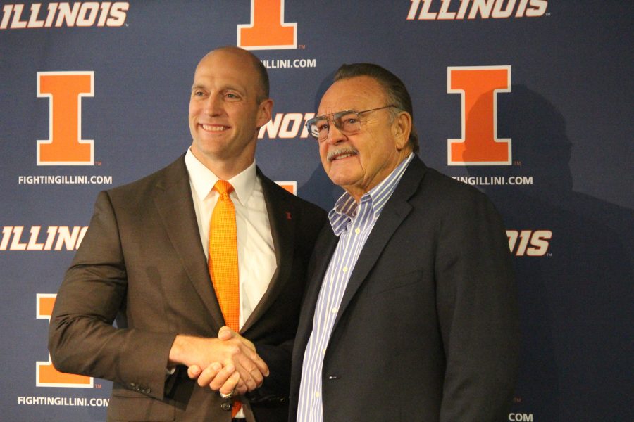Honoree Dick Butkus shakes hands with Athletic Director Josh Whitman at the Memorial Stadium on Thursday.