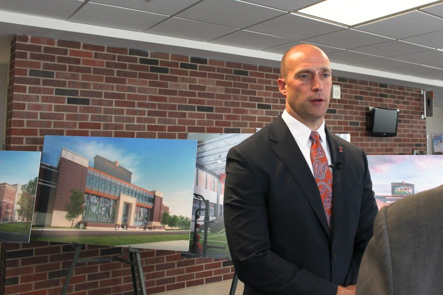 Athletic director Josh Whitman stands near early renderings of stadium renovations while speaking at a press conference in Memorial Stadium on Monday.