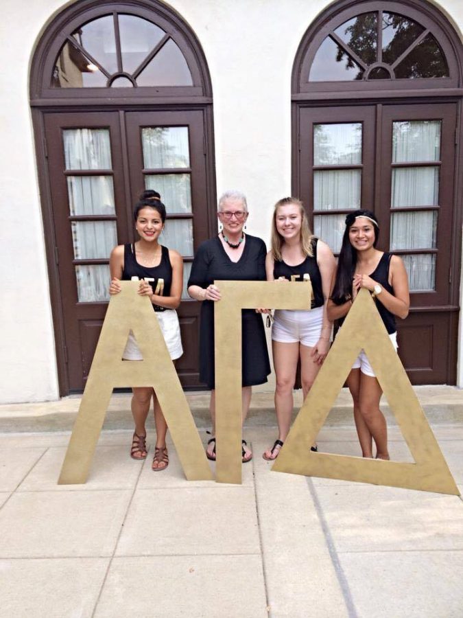 Alpha Gamma Delta house mom Caron Barnhart, center, poses with sorority members in front of the AGD house.