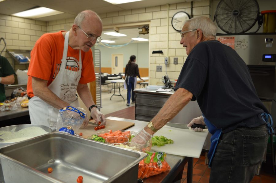 Volunteers John Neff and Tony Peressini work together to prepare a fresh salad to be served at lunch at the Daily Bread Soup Kitchen on Nov. 10, 2015.