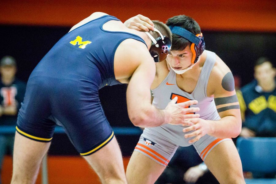 Illinois Isaiah Martinez wrestles with Michigans Logan Massa in the 165 pound weight class during the match at Huff Hall on Friday, January 20.