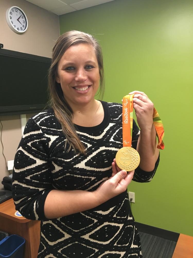 Nicole Millage holds up her gold medal from the 2016 olympics in Rio. Millage competed in the sitting volleyball games. 