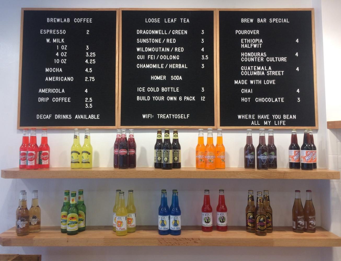 The+menu+at+BrewLab+sits+above+the+stores+craft+soda+bottles.+BrewLab%2C+recently+opened+and+located+in+Campustown%2C+serves+specialty+espresso+drinks+as+well+as+craft+soda.+