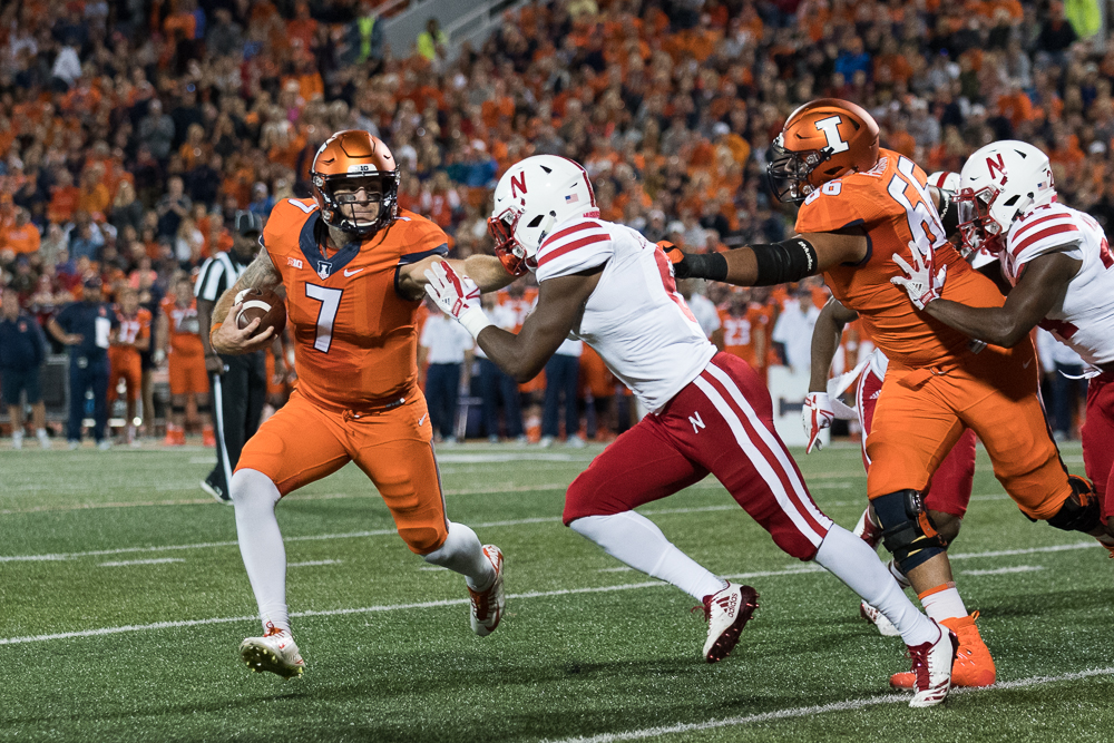Illinois quarterback Chayce Crouch stiff-arms a defender during the game against Nebraska at Memorial Stadium.  The Illini lost 28-6.