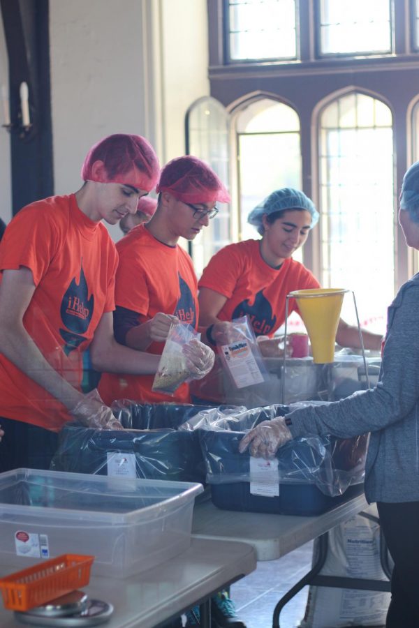 Volunteers at Illini Fighting Hungers 2017 iHelp event help package meals for those struggling with food insecurity.