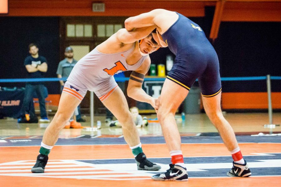 Illinois Isaiah Martinez wrestles with Michigans Logan Massa in the 165 pound weight class during the match at Huff Hall on Friday, Jan. 20. Martinez won by decision and the Illini defeated the Wolverines 34-6.