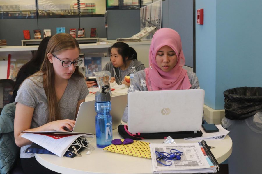 Sophomores Eva Bucke and Hazirah Muhamad work on a project together at the Undergraduate Library. Group projects can be beneficial because they allow students to learn how to work together.