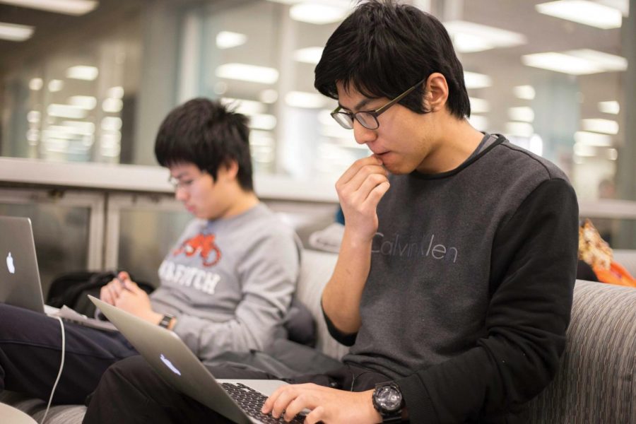 Zhining Qiu, freshman in general studies, and Chengcheng Gan, freshman in Engineering Physics, studying for finals in the Undergraduate Library on Dec. 12. Libraries across campus will be open longer the next two weeks to satisfy demand.
