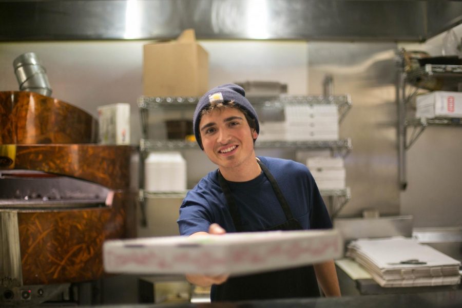 Zach Deliberto serving pizza at Mia Zas on Green Street on Dec. 1, 2017. Zas is one of many businesses who regularly partners with RSOs on campus to support certain causes.