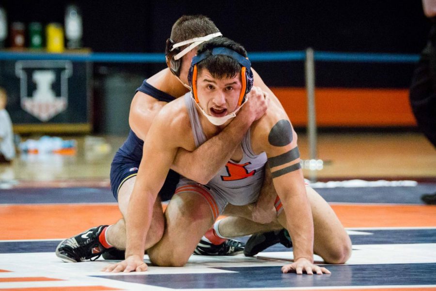 Illinois' Isaiah Martinez wrestles with Michigan's Logan Massa in the 165 pound weight class during the match at Huff Hall on Friday, January 20. Martinez won by decision and the Illini defeated the Wolverines 34-6.