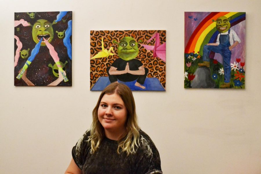 Alethea Busch creates Shrek paintings to challenge commercialized art. The featured paintings are “Gimme Dat O-gurt,” “The Yogre Instructor,” and “Somewhere Ogre the Rainbow.”